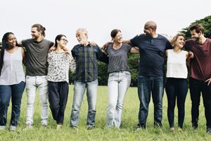 Group of people with their arms around each other in a field