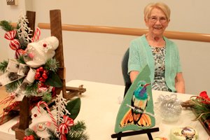 Senior posing with handmade knit items